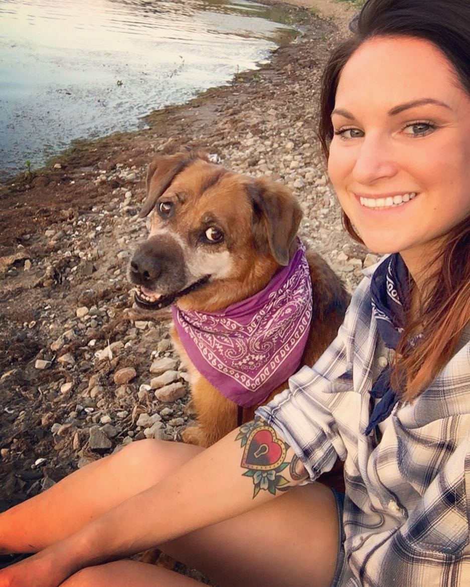 Dog Trainer Cora Wittekind on the beach with her dog Alice wearing bandana