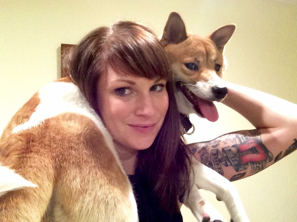 Dog Trainer Cora Wittkind smiles as Shiba Inu dog sits on her shoulders